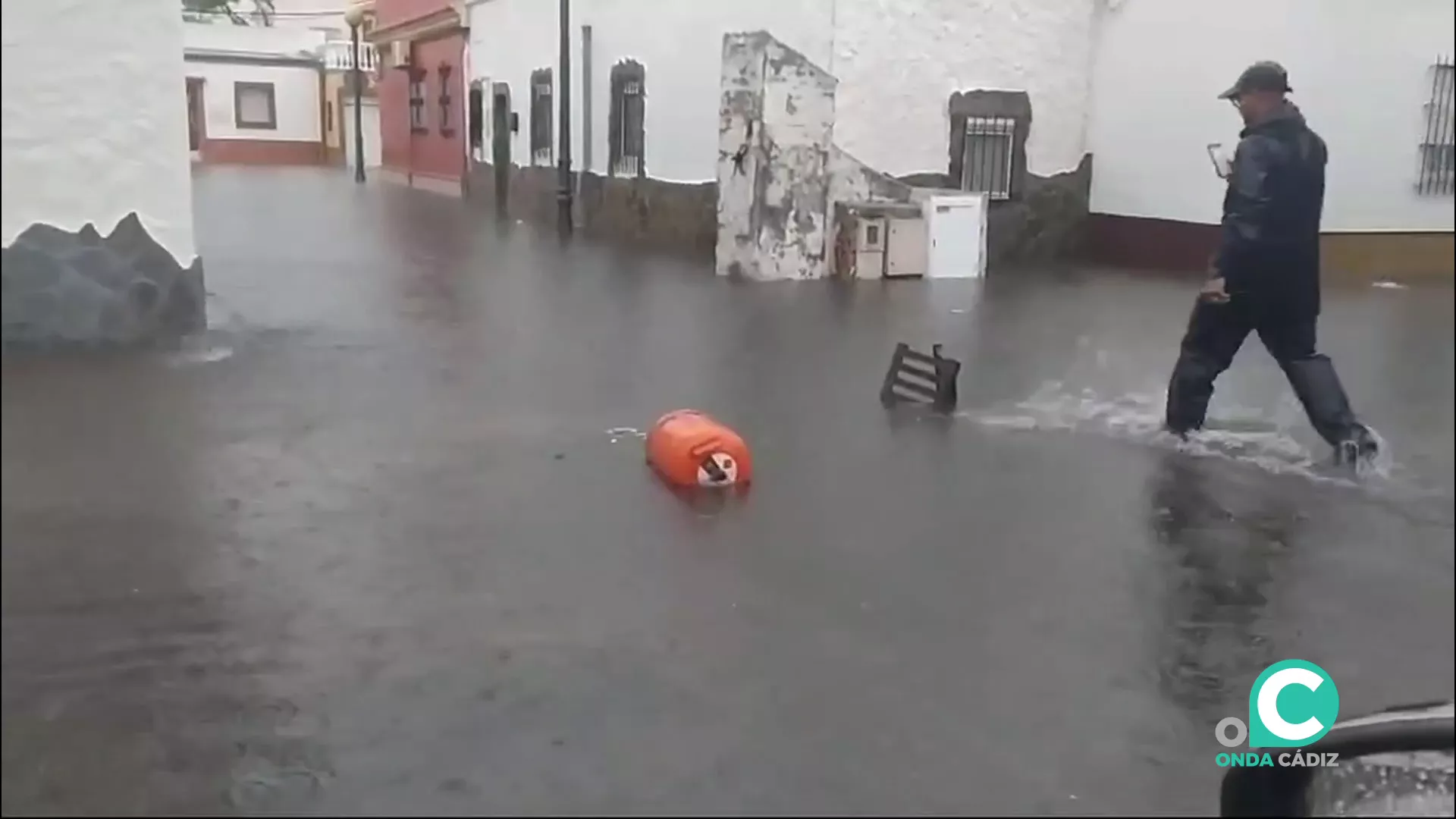 Un hombre se abre paso por una calle inundada en una barriada isleña.