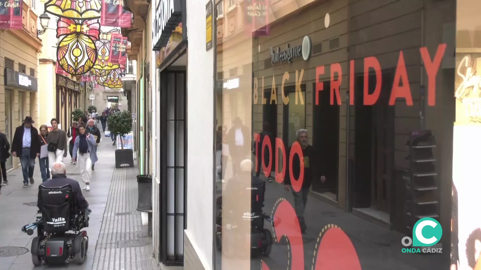 Imagen de la calle Columela, donde se puede apreciar en un escaparate los descuentos del Black Friday. 