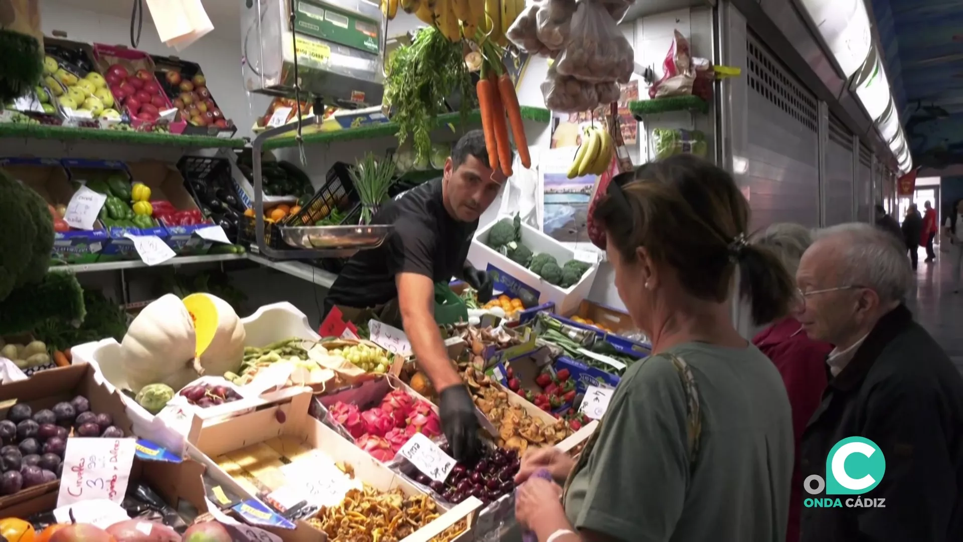 Un detallista con sus clientes este viernes en el Mercado Virgen del Rosario