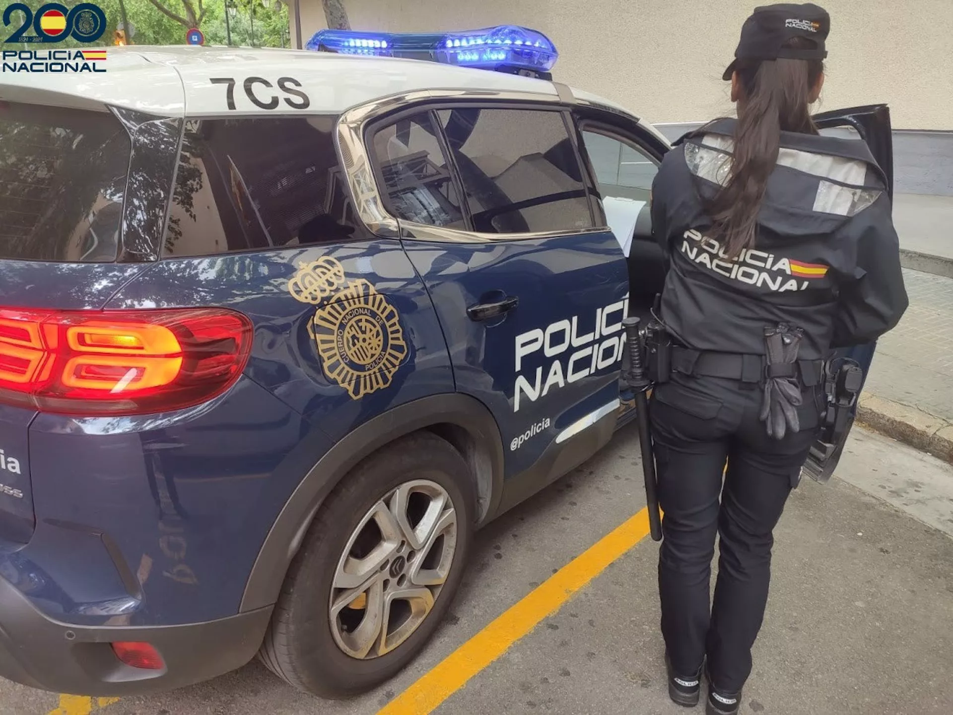 Una agente de la Policía Nacional junto a un coche patrulla en una imagen de archivo