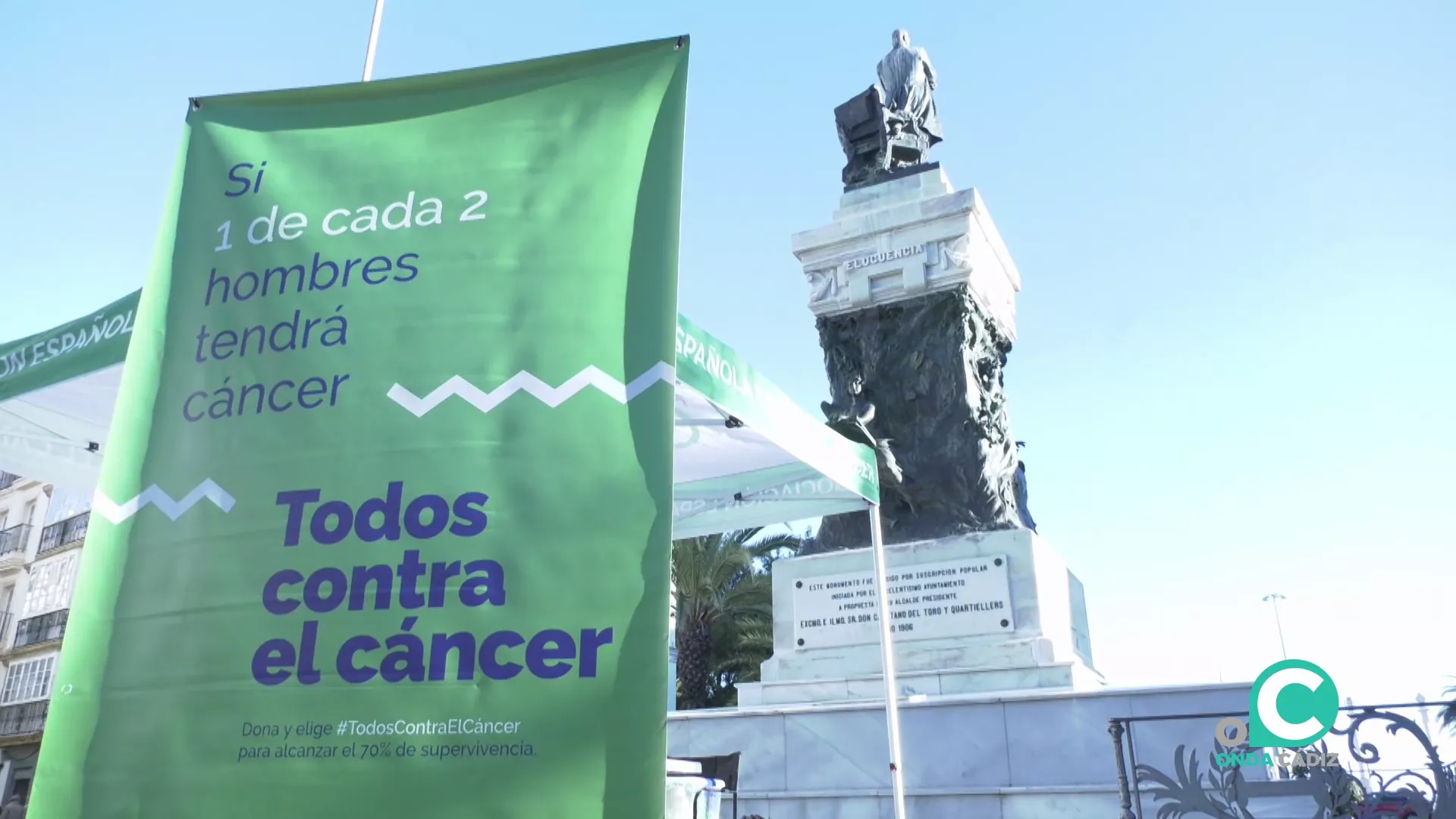 La estatua de Moret destaca sobre uno de los carteles desplegados esta jornada por la Asociación Española Contra el Cáncer