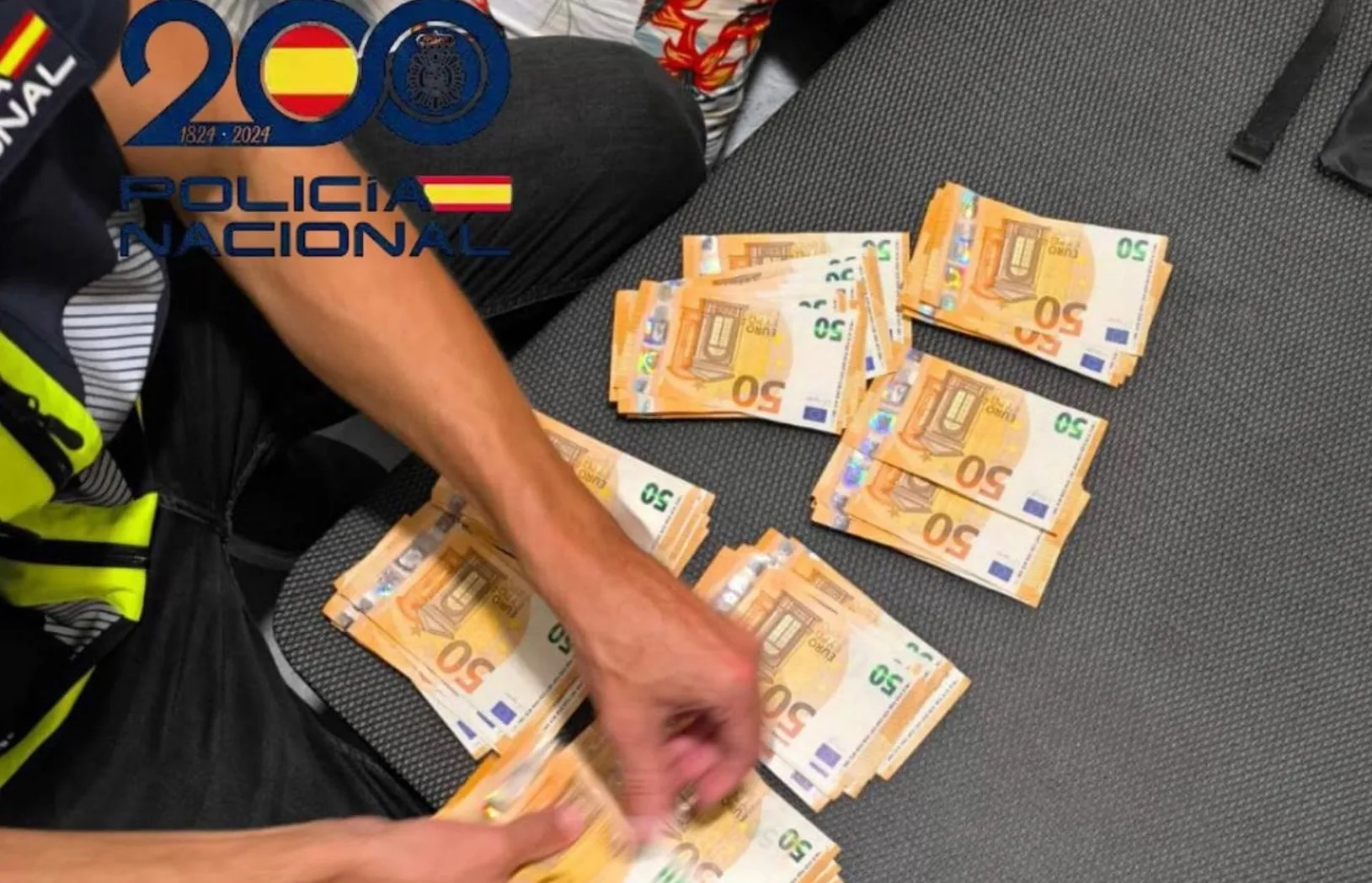 Un agente contando dinero incautado durante las acciones policiales Un agente contando dinero incautado durante las acciones policiales