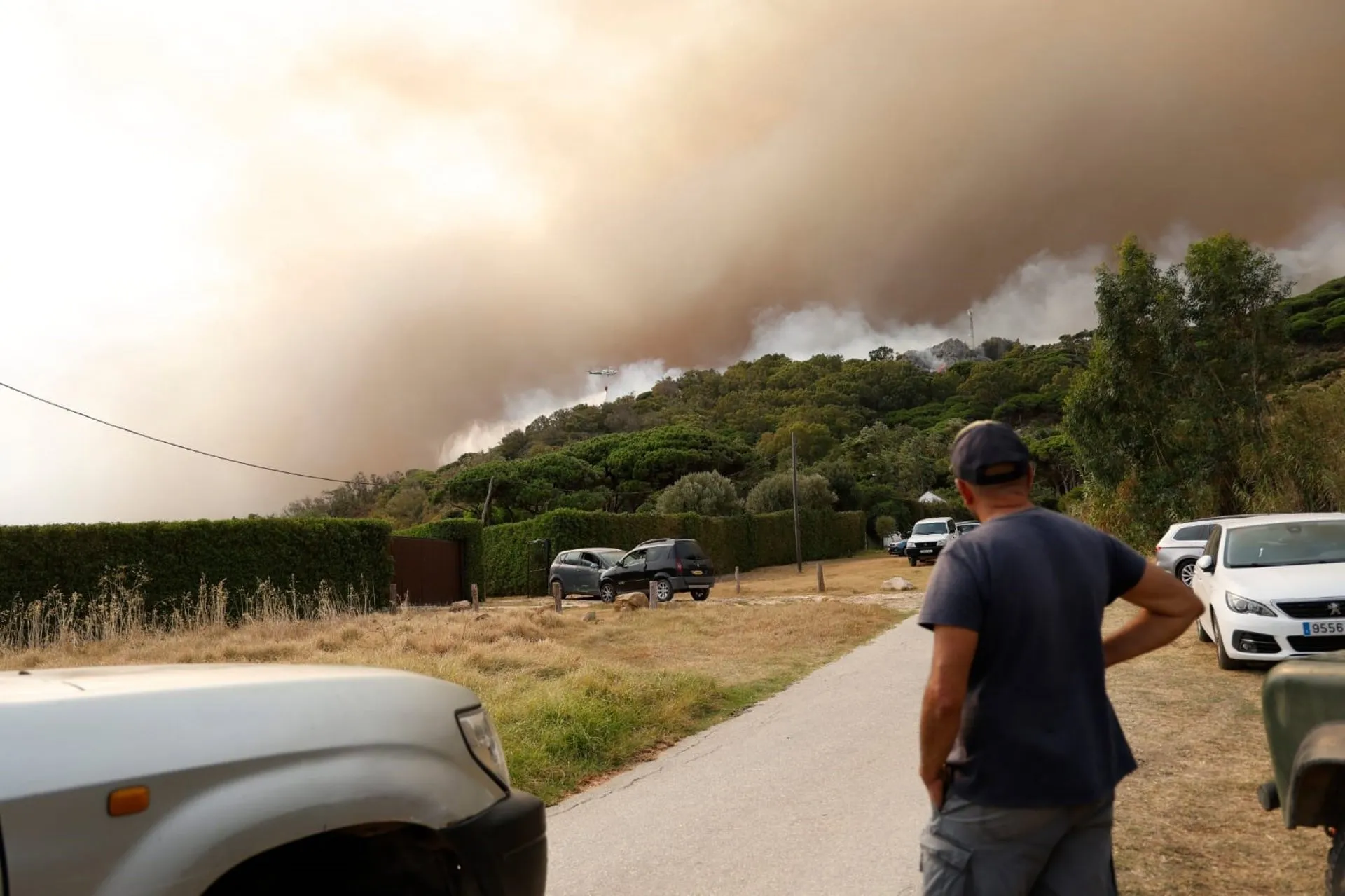 Una persona observa las columnas de humo originadas por el siniestro. Una persona observa las columnas de humo originadas por el siniestro.