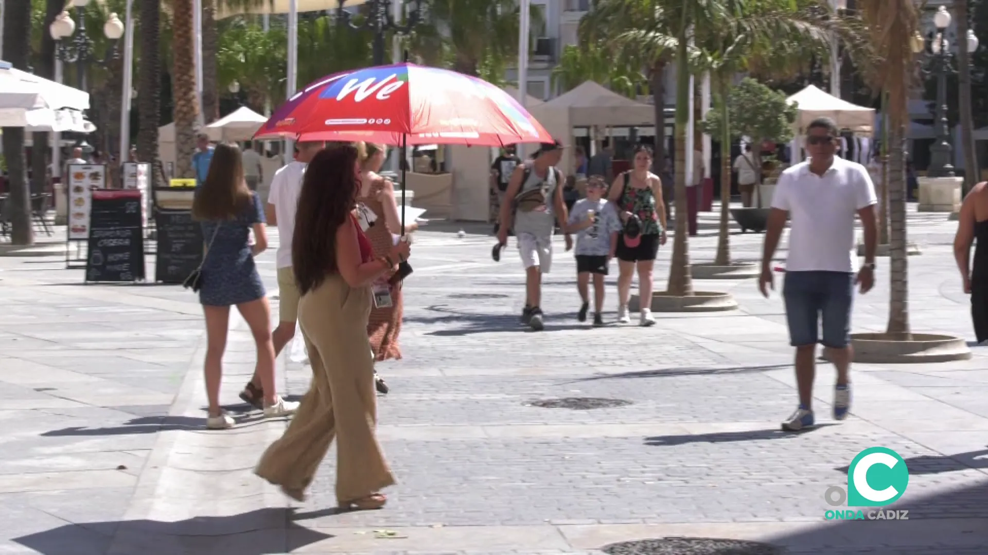 Una mujer se protege del sol en la plaza de San Juan de Dios Una mujer se protege del sol en la plaza de San Juan de Dios