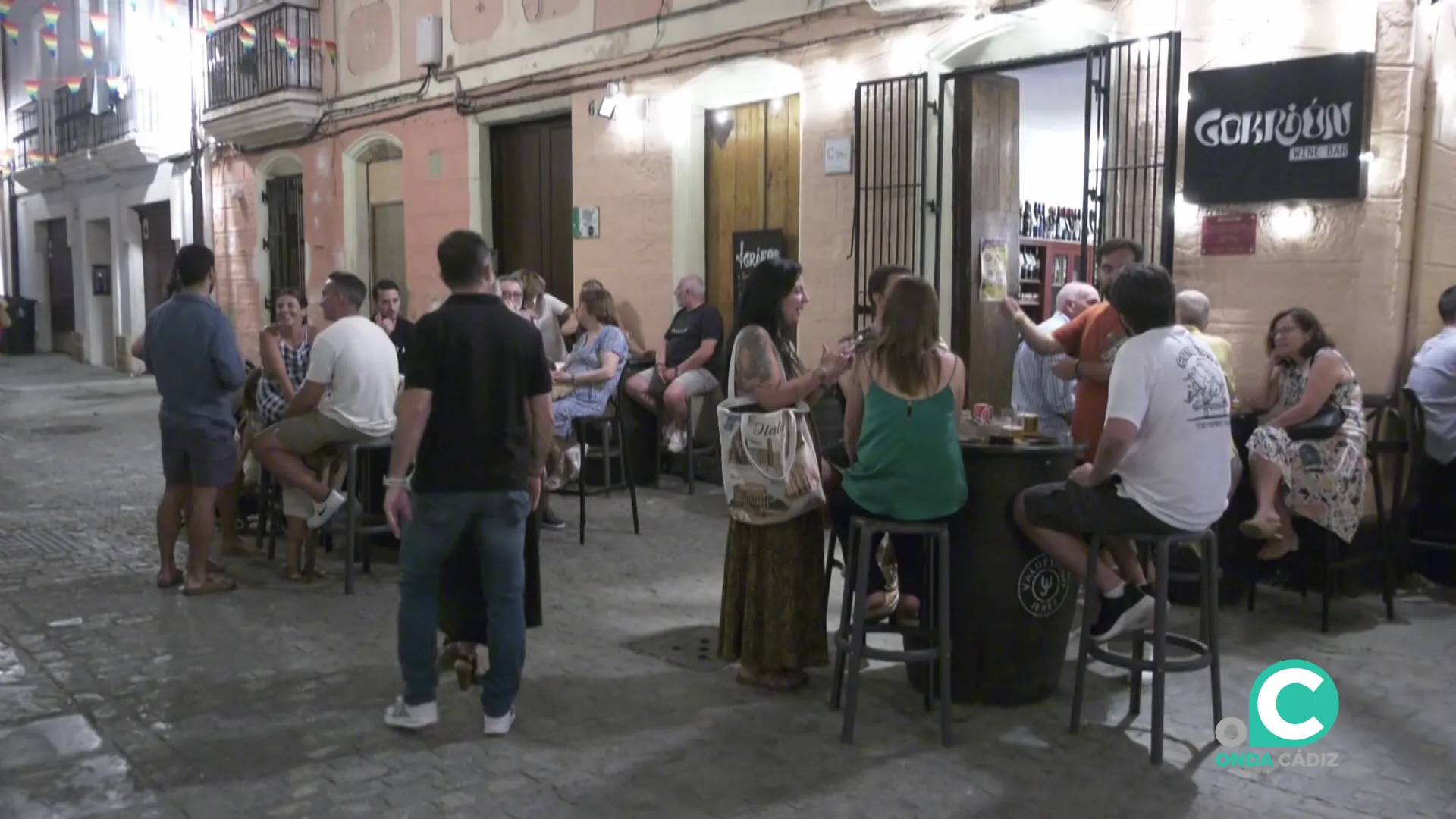 Clientes en las mesas del exterior en un establecimiento en el centro de la ciudad
