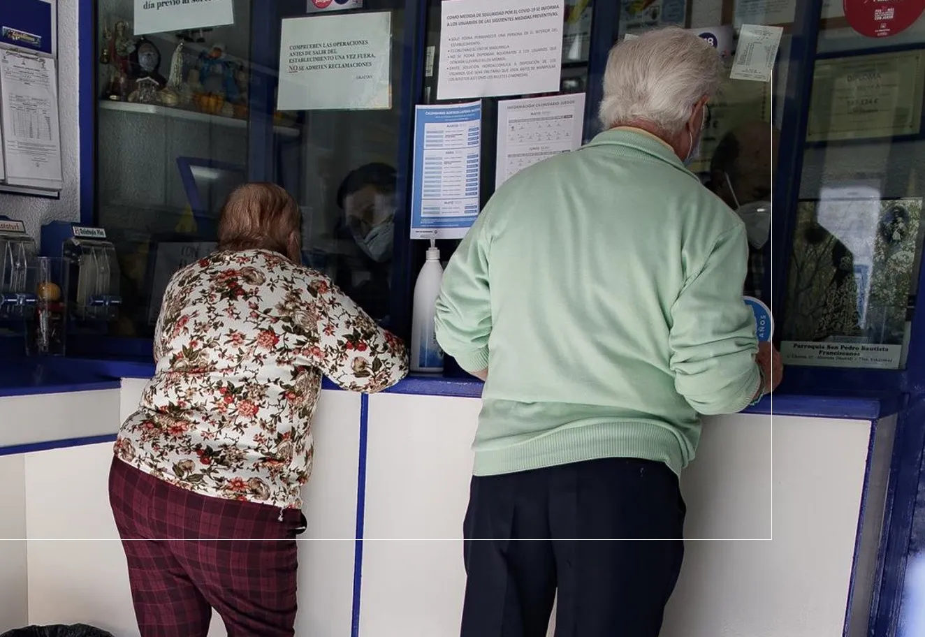 Un hombre y una mujer compran lotería en una imagen de archivo