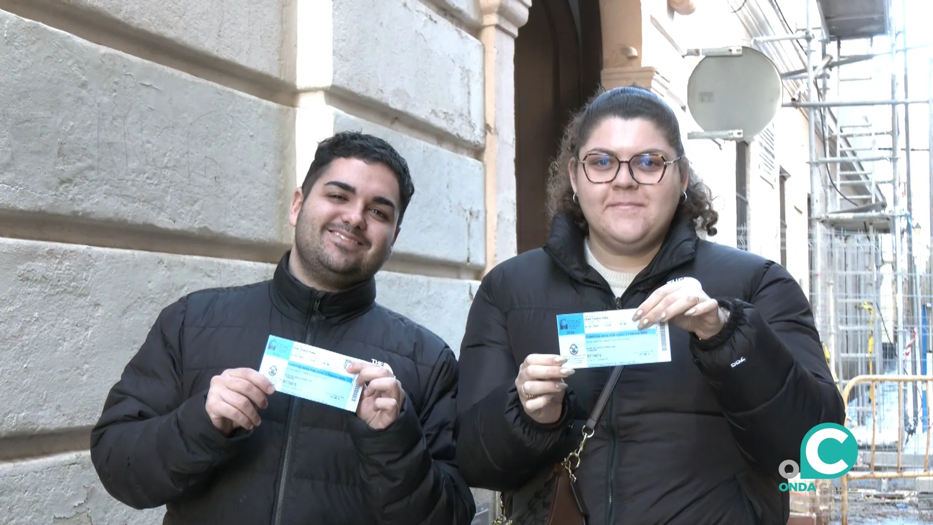 Dos aficionados al carnaval muestran las entradas que han adquirido este sábado. 