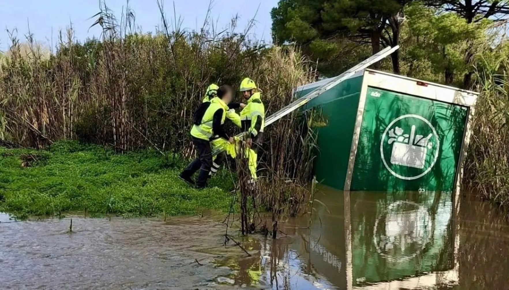 Efectivos de bomberos observan el estado del vehículo siniestrado