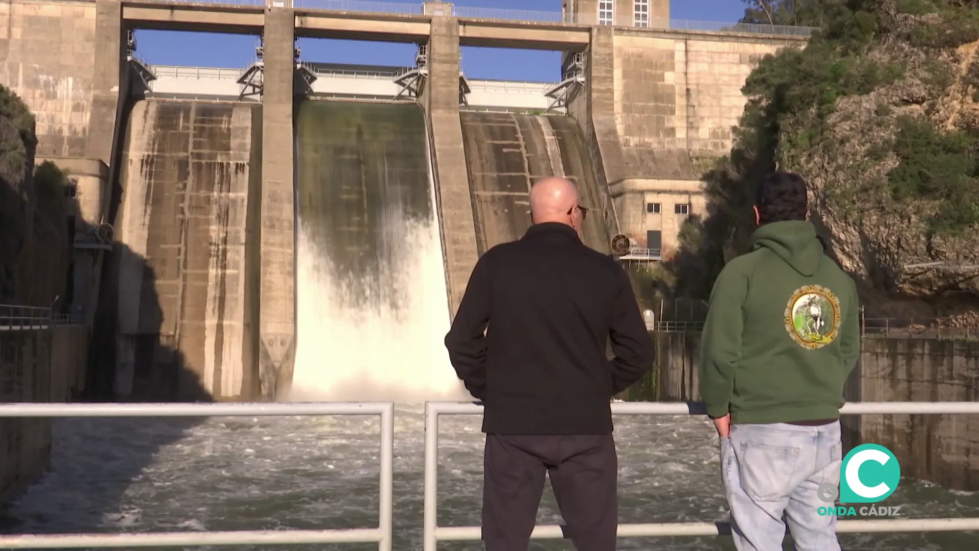 Dos personas observan la caida de agua de los Hurones