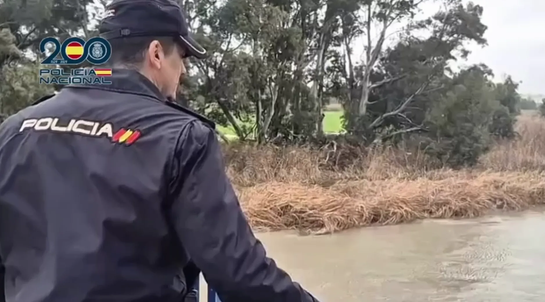 Un policía nacional observa la zona inundada por el rio Guadalete en el termino de Jerez