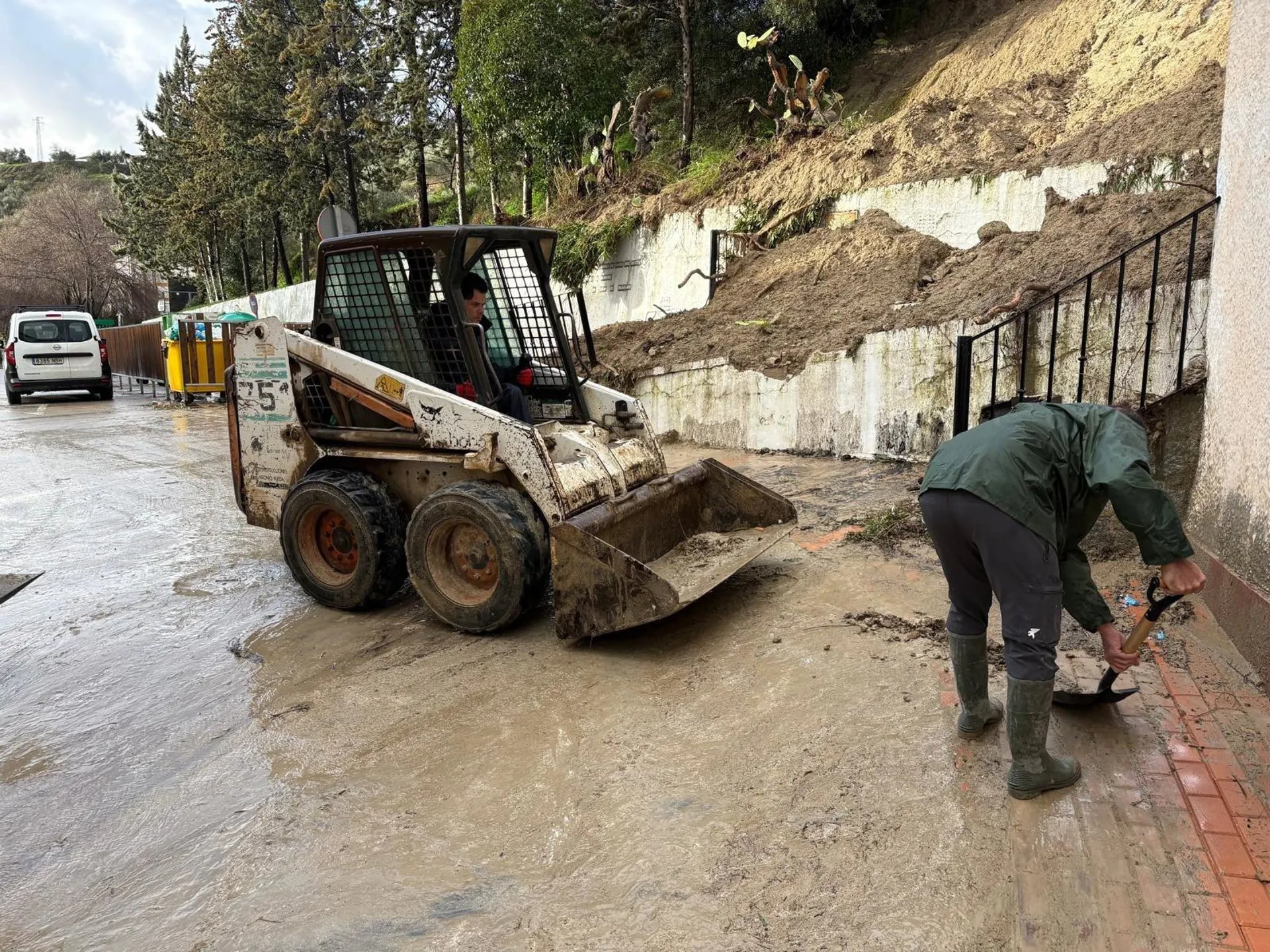 Operarios de Alcalá del Valle trabajan en una calle sobre los efectos del temporal de lluvia.
