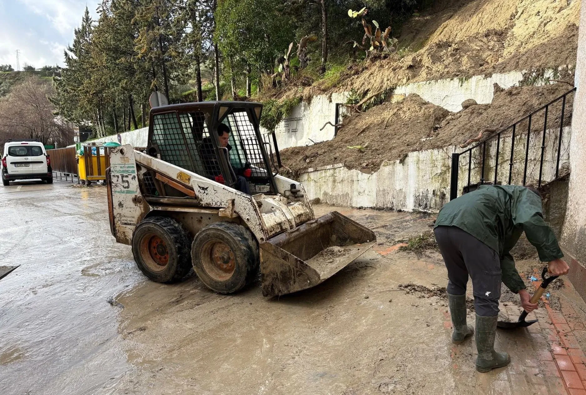 Operarios de Alcalá del Valle trabajan en una calle sobre los efectos del temporal de lluvia.