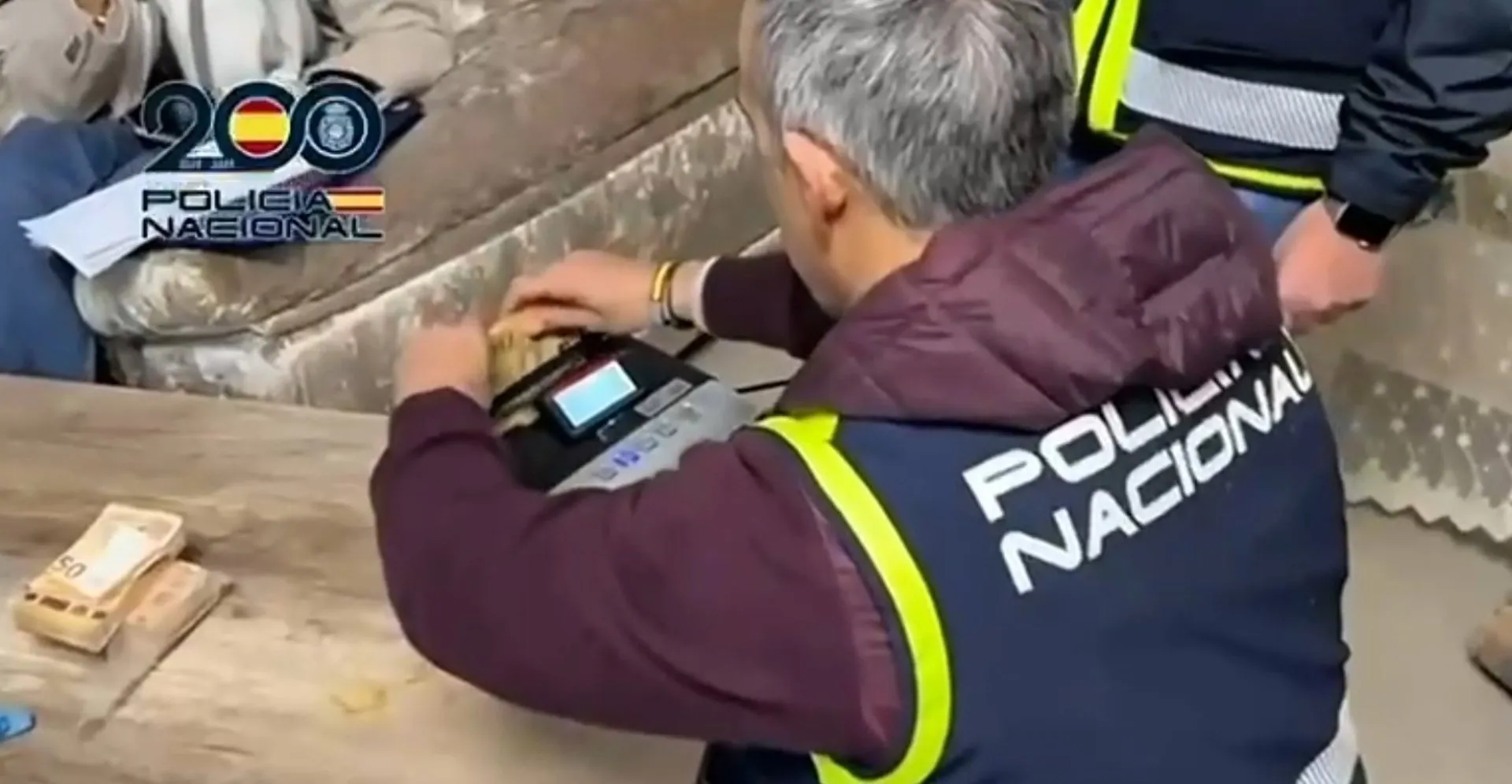 Un agente cuenta dinero intervenido a una organización dedicada al tráfico de armas para el narcotráfico.