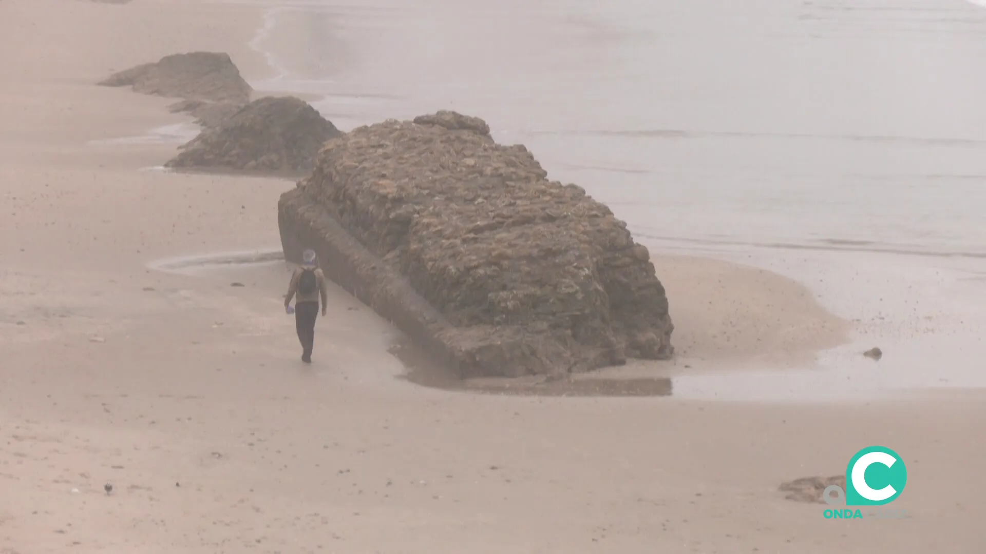 Un hombre pasea junto a uno de los antiguos lienzos sobre la arena