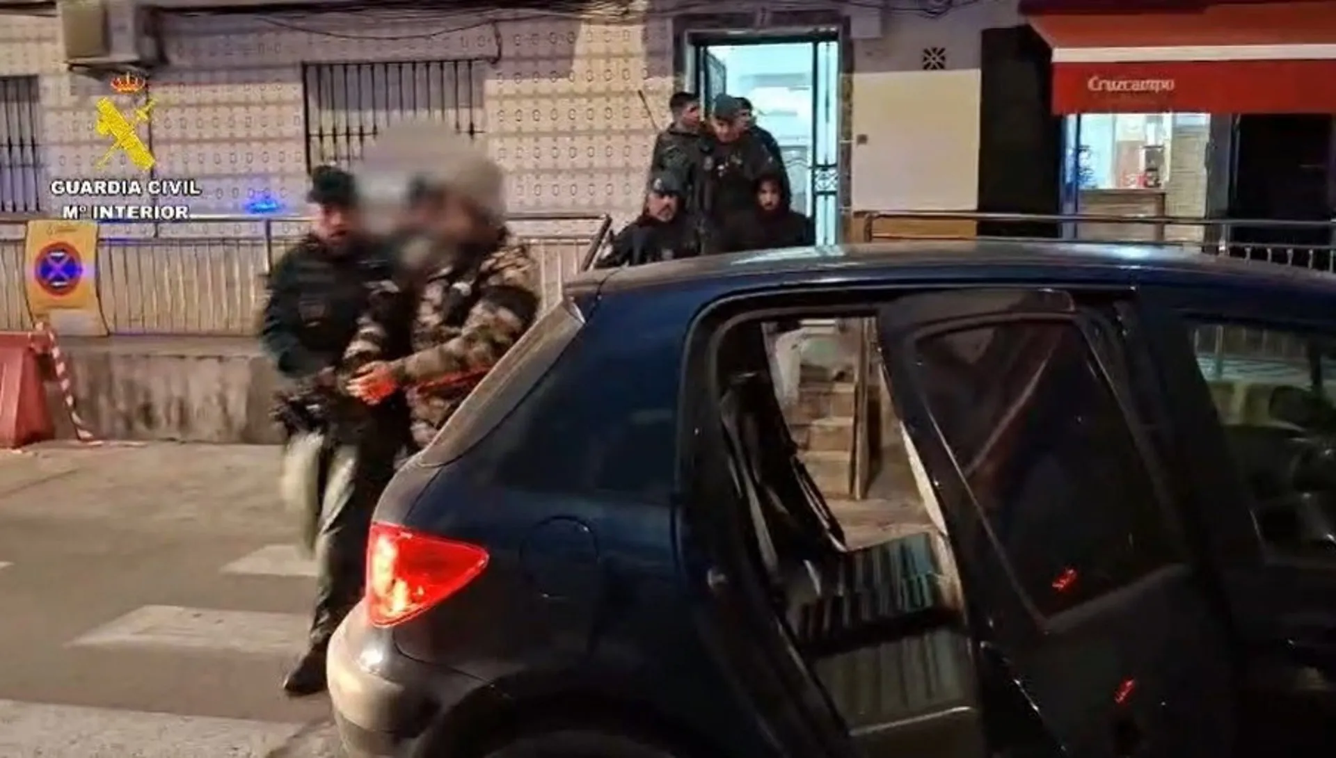 Agentes escoltan a uno de los arrestados en el operativo