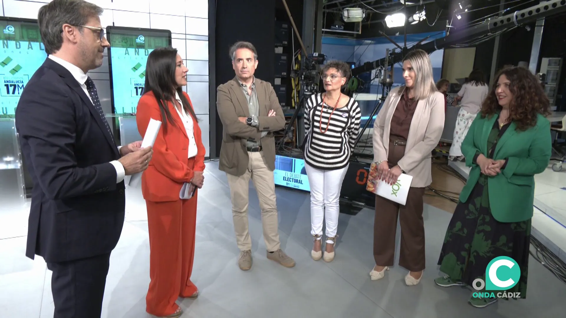Algunos de los participantes dialogan por antes del comienzo en los estudios de la televisión local