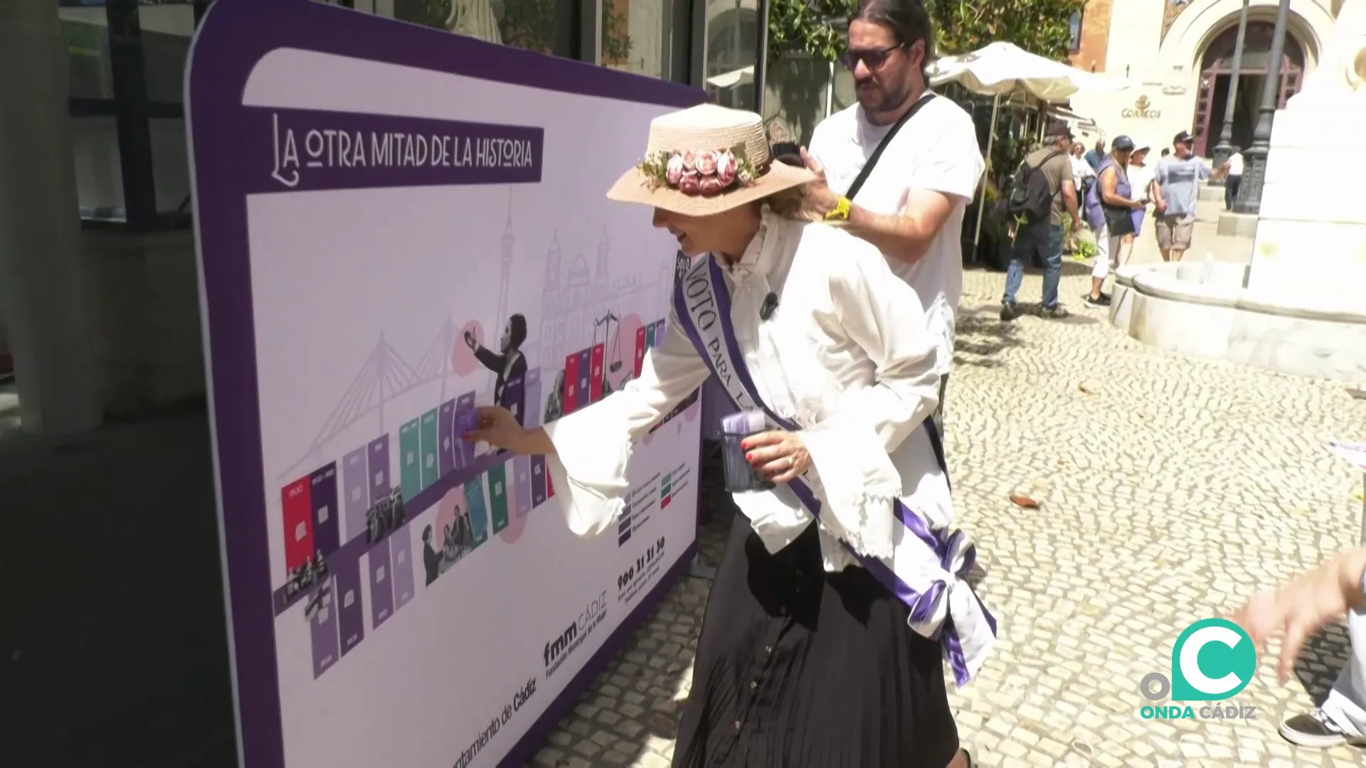 Una sufragista marca el mural de línea de tiempo instalado en la capital gaditana.