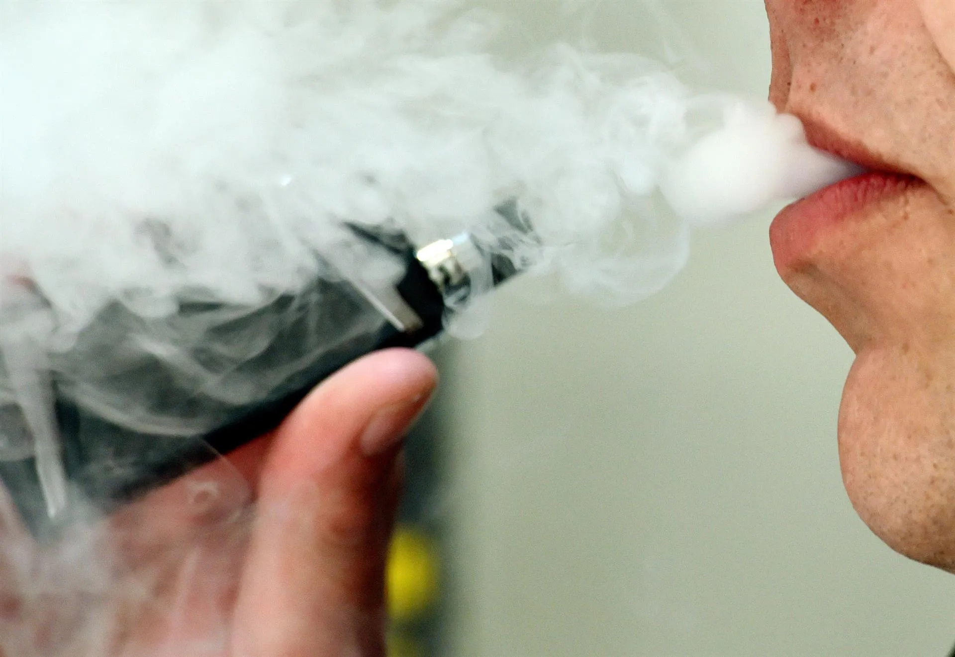  Un hombre exhalando mientras usa un vapeador
